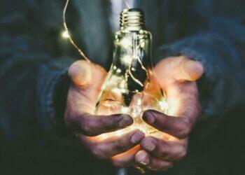 Person holding a lit lightbulb (Unsplash | pavement_special)