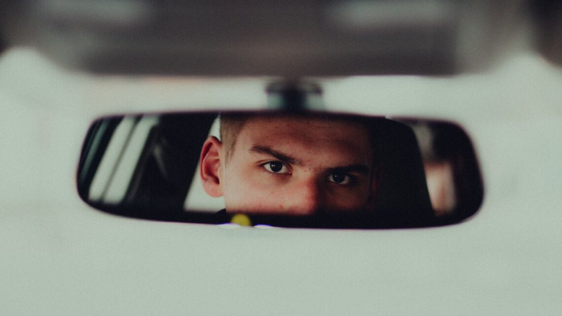 Man looking in car mirror