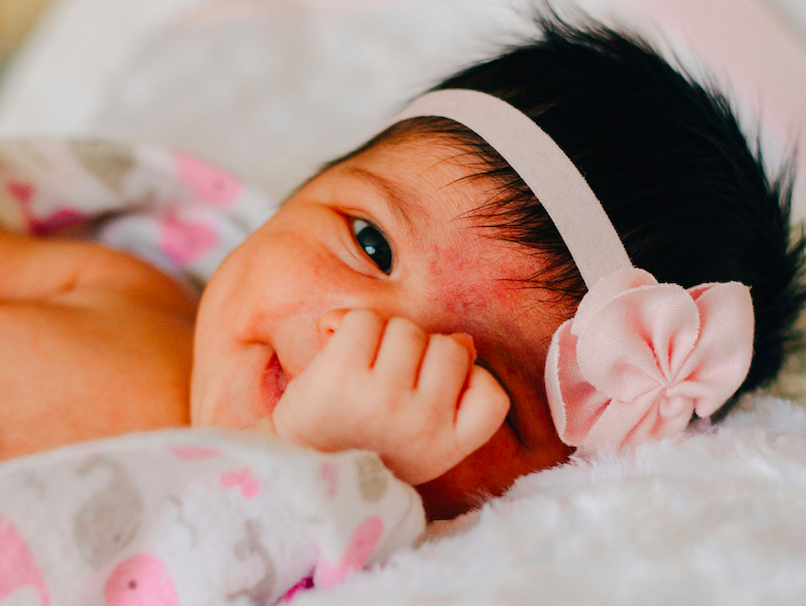 Newborn baby in pink bow
