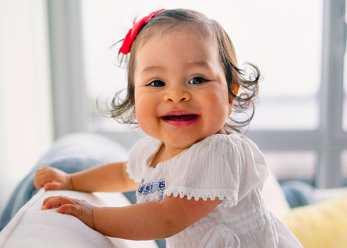 Baby smiling in pink bow
