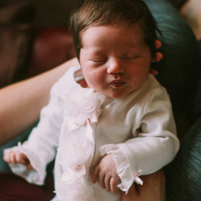 Baby sleeping in white and pink onesie