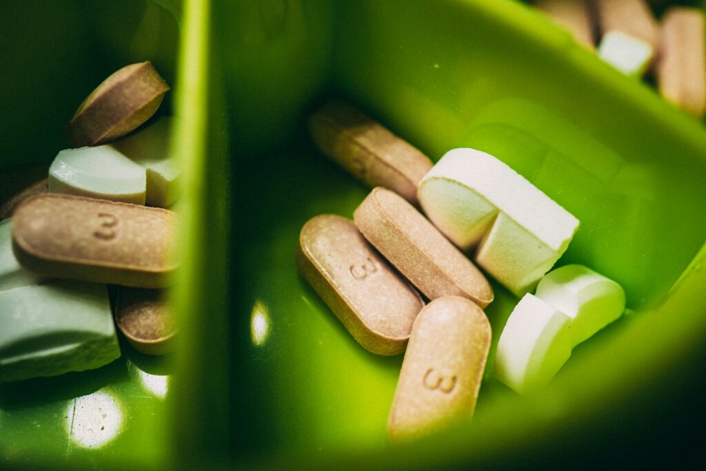 white medication pills in green plastic container