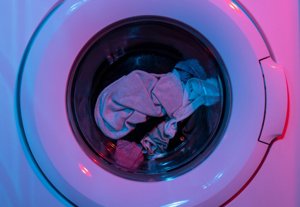 a picture of the front of a washing machine with clothes inside