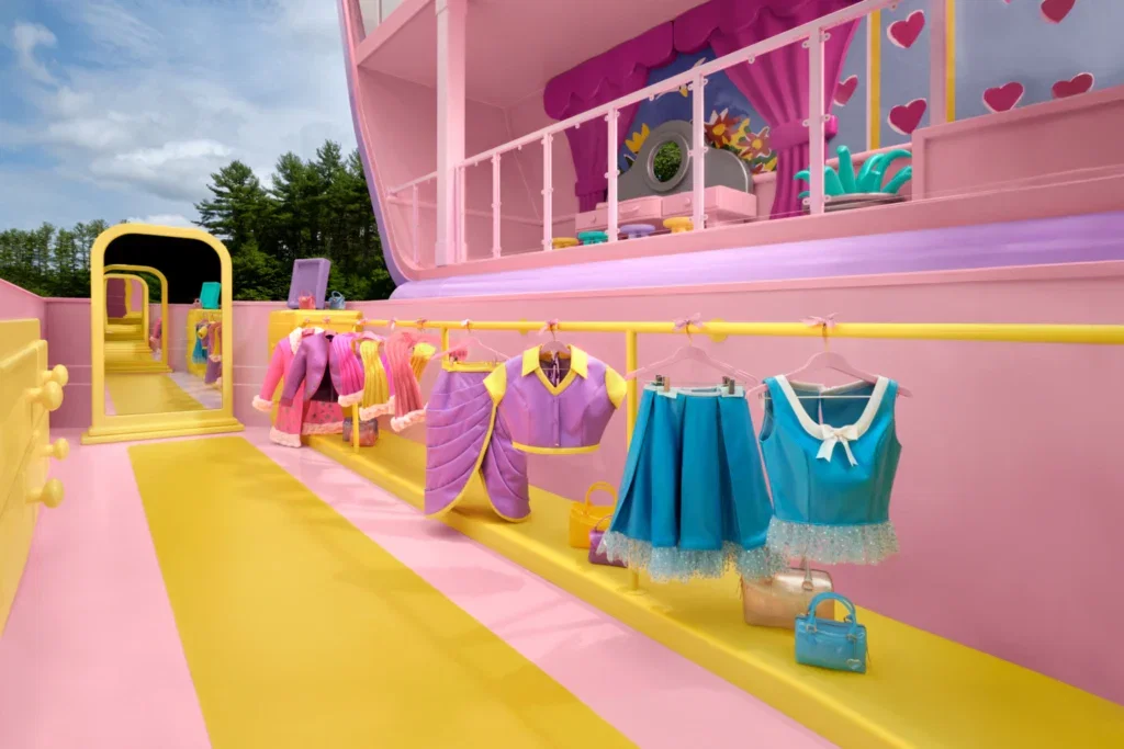 Life-size versions of Polly Pocket’s clothes hanging on a yellow clothing rack 