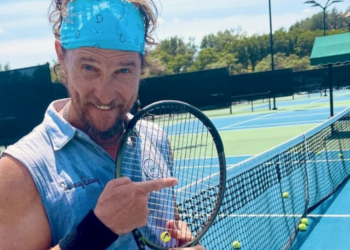 matthew mcconaughey on a tennis court holding a tennis racket