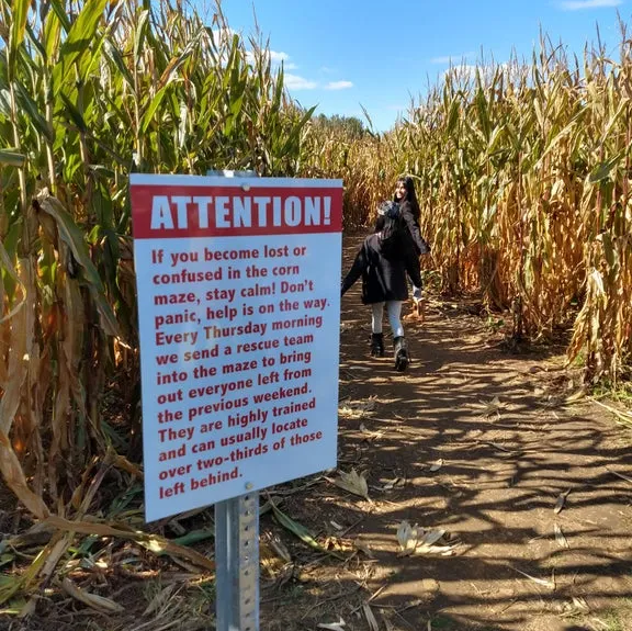 a sign in a corn maze that says “ If you become lost or confused in the corn maze, stay calm! Don't panic, help is on the way.
Every Thursday morning we send a rescue team into the maze to bring out everyone left from the previous weekend.
They are highly trained and can usually locate over two-thirds of those left behind.”