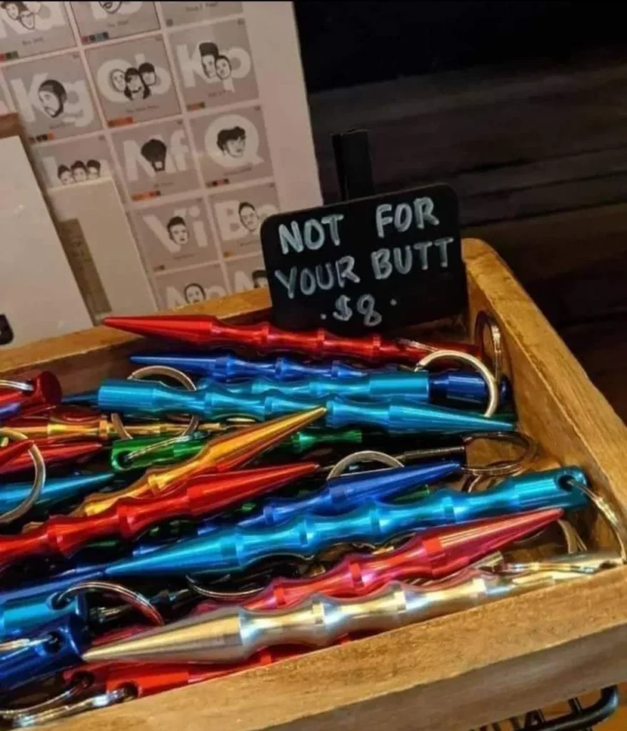 a pile of keychains with a sign on it that says “not for your butt $8”