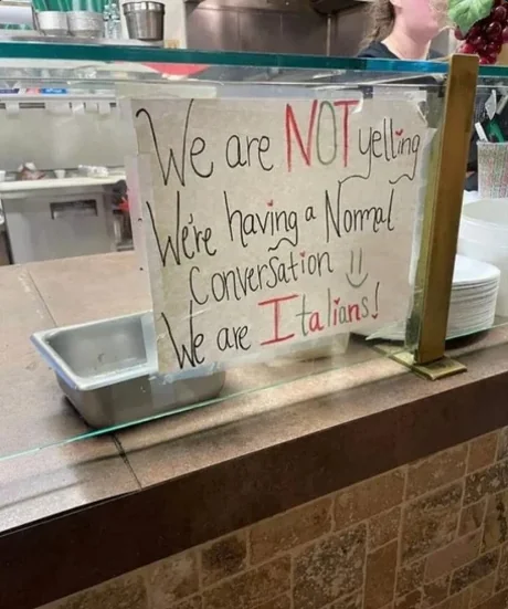 a sign that says “we are NOT yelling we’re having a normal conversation smiley face. we are italians!