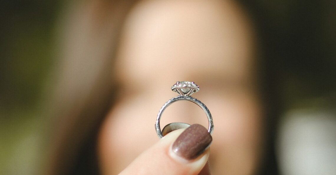 shallow focus photography of woman holding a diamond ring