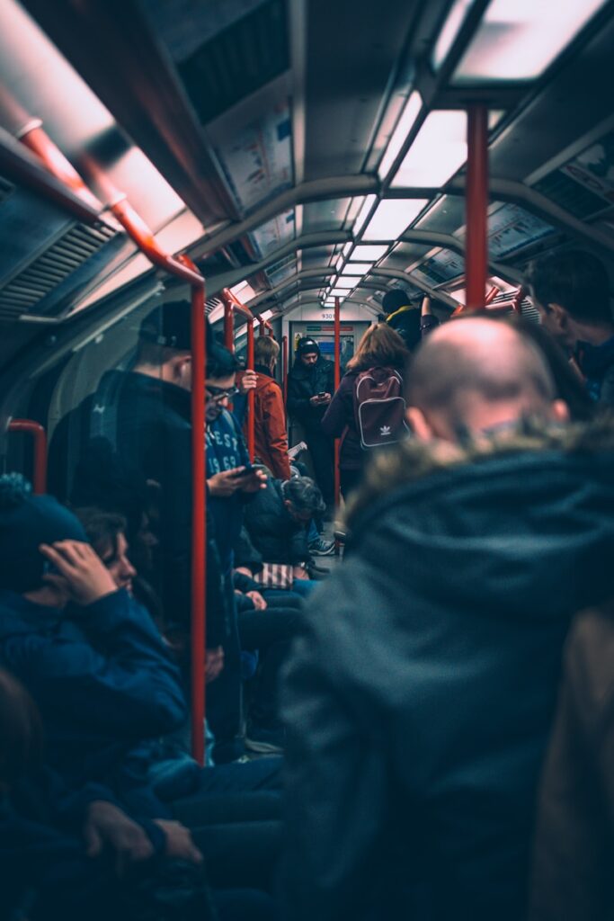 A bunch of people standing inside a public transportation car 