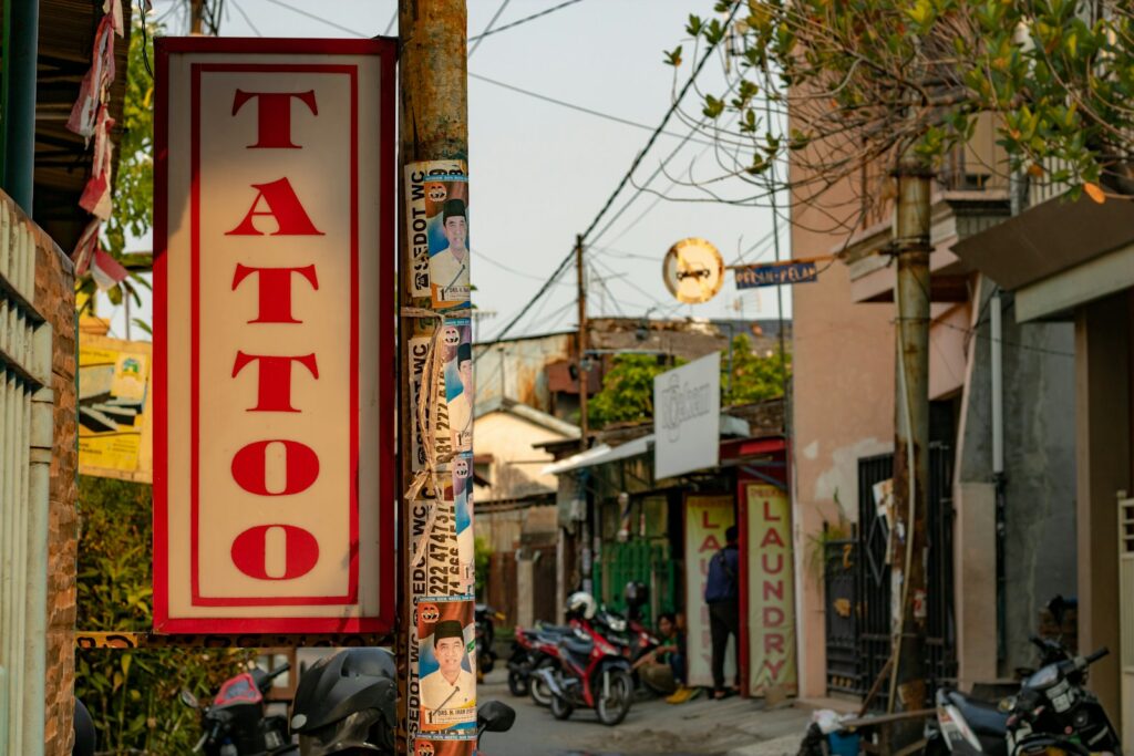 tattoo sign next to a street in daytime