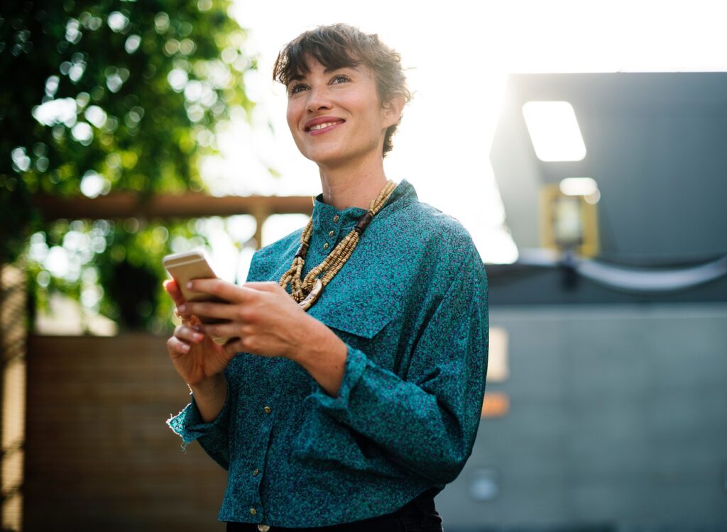 a woman walking while holding a cell phone