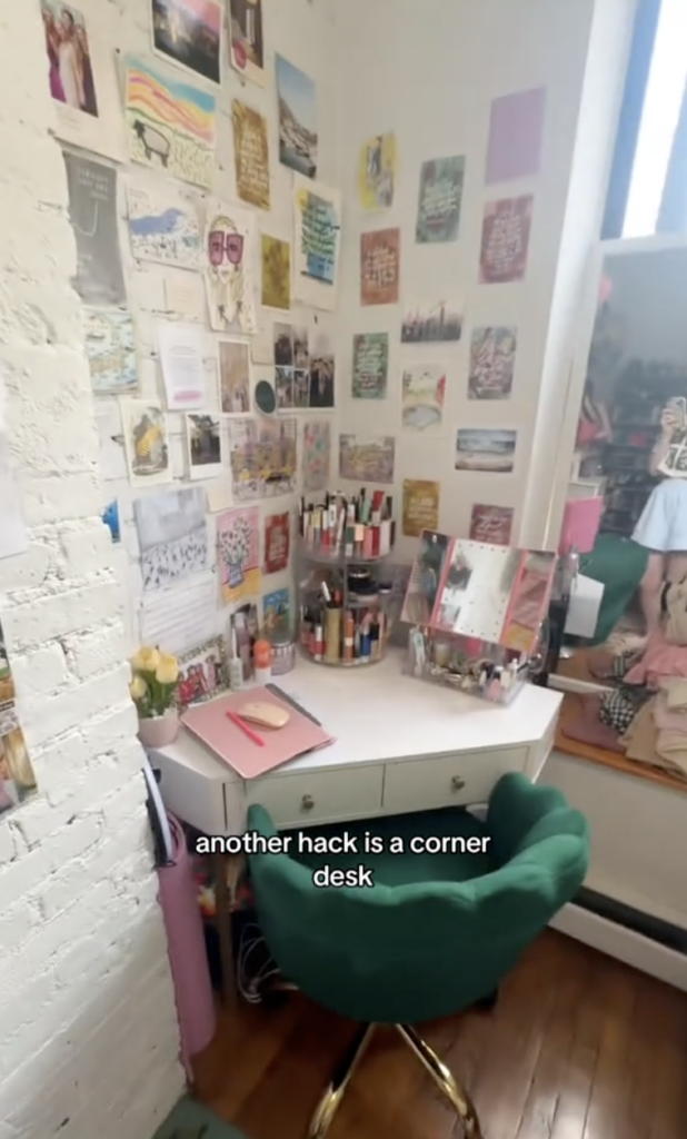 A corner desk with items on top with a green office chair in front of it.