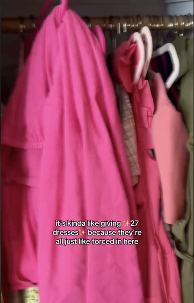 Clothing hanging in a small closet.