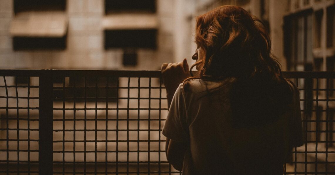 sad woman overlooking apartment complex