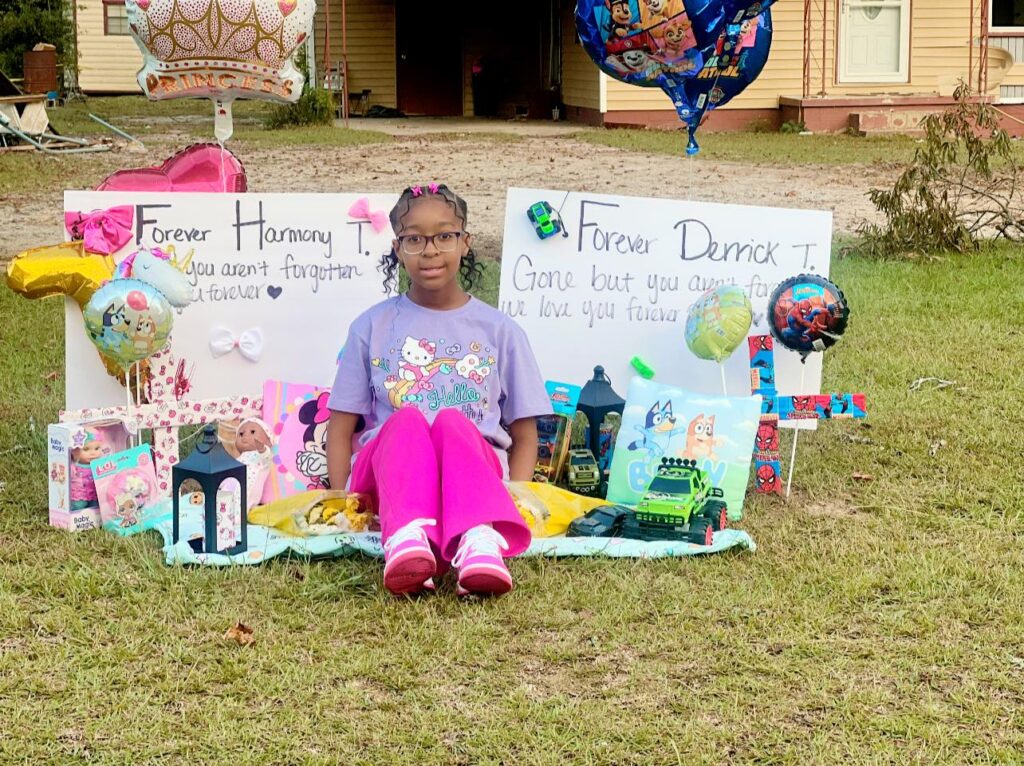 Cassidy Taylor sitting in front of memorials for her two siblings