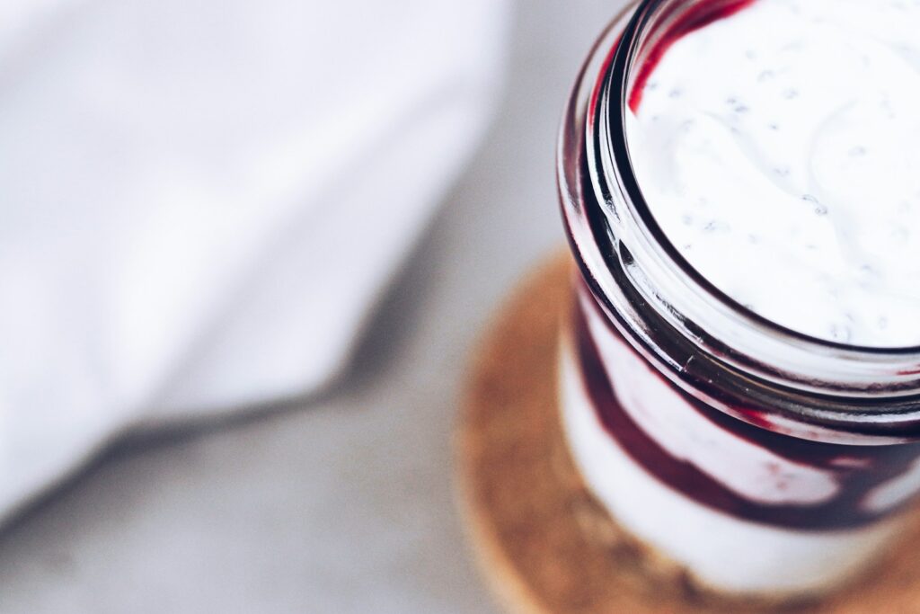 A glass jar filled with liquid sitting on top of a wooden coaster