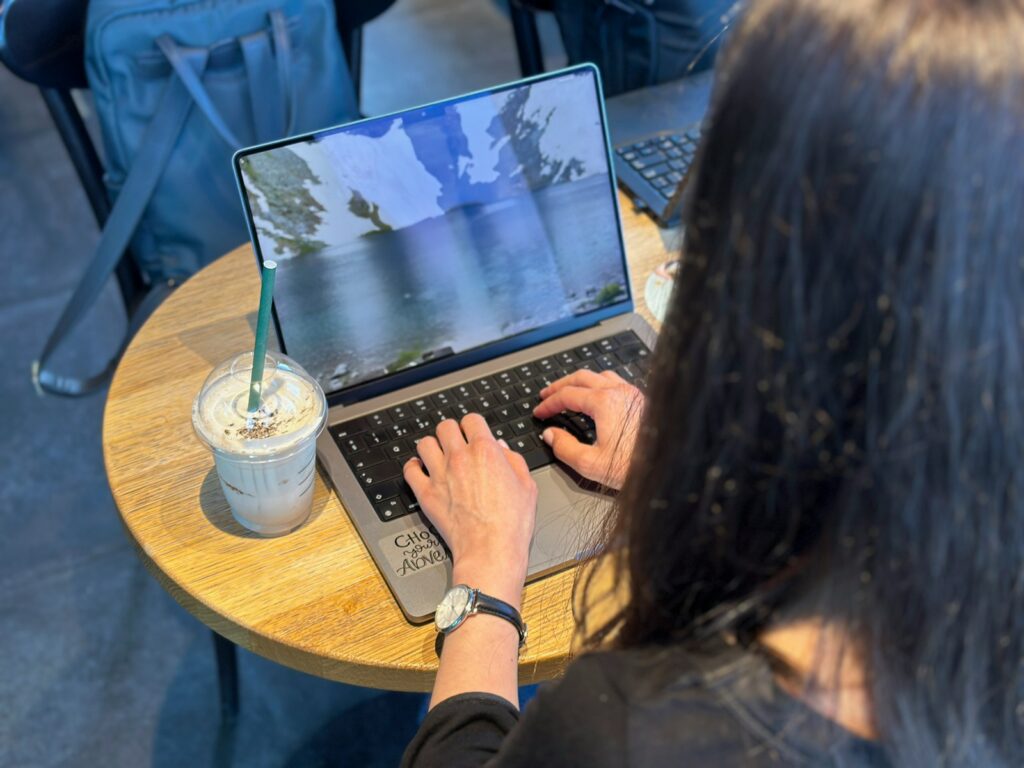 a woman sitting at a table using a laptop computer
