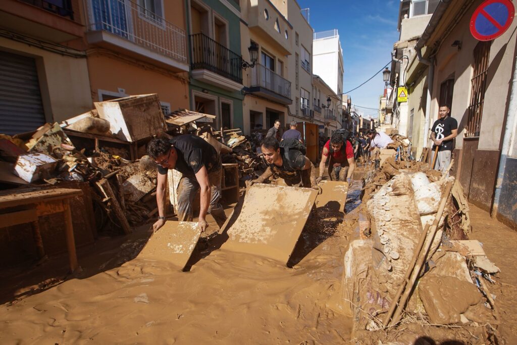 Residents work to remove mud from a street in Paiporta on Friday.