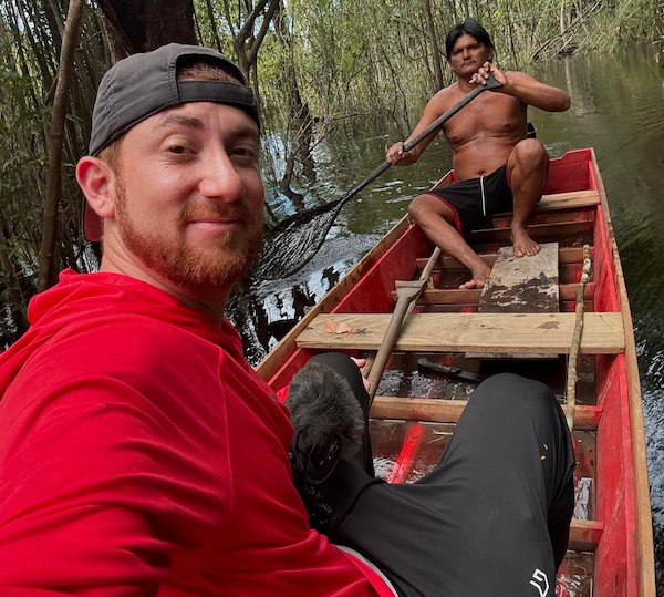 Drew Binsky on a boat in the Amazon