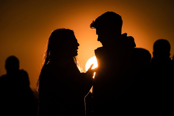 Silhouette of a couple at sunset as they wait to see the...