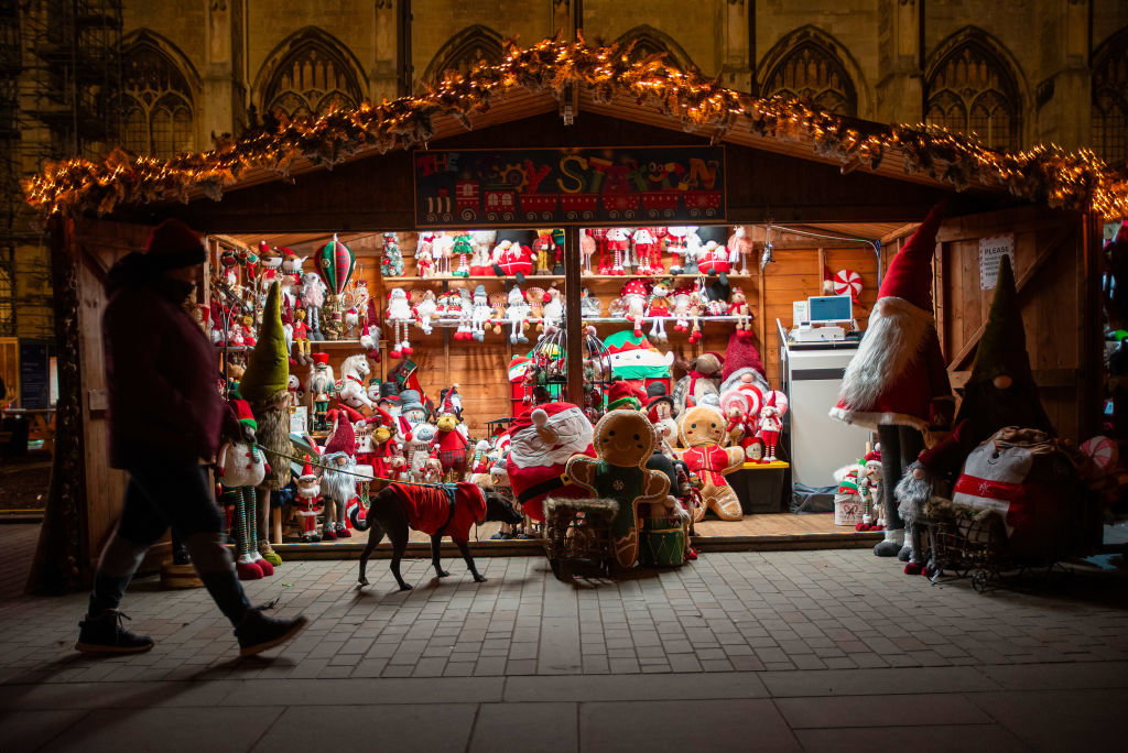 A man walks with his dog in front of the soft toy shop at...