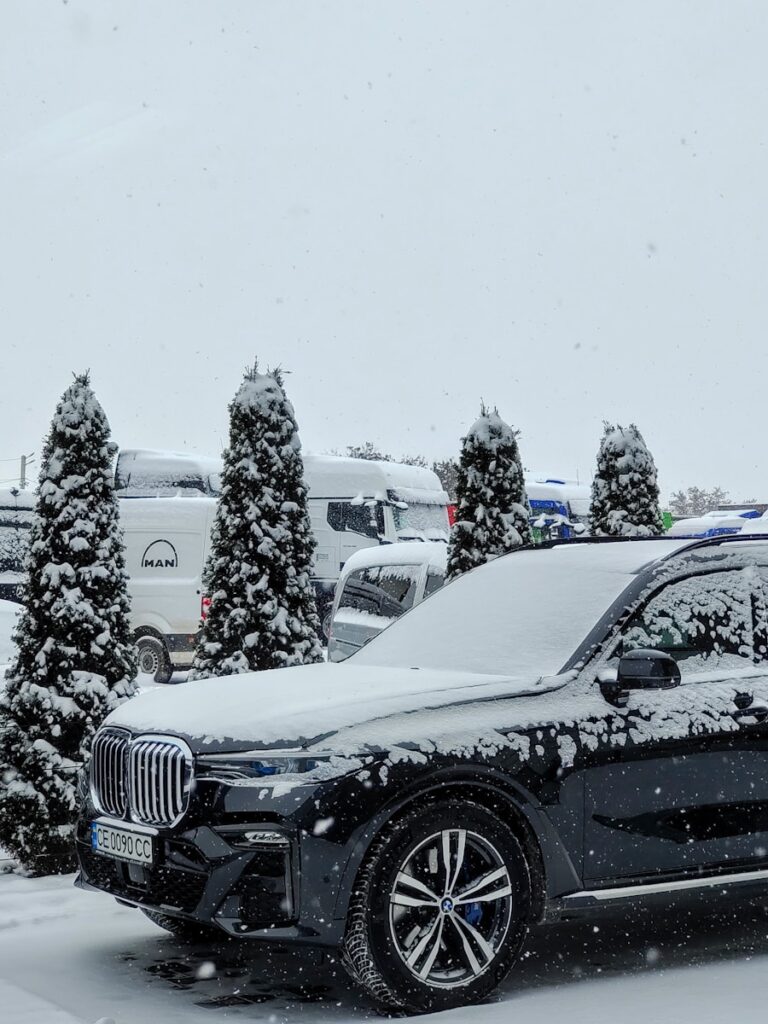 a car is covered in snow in a parking lot