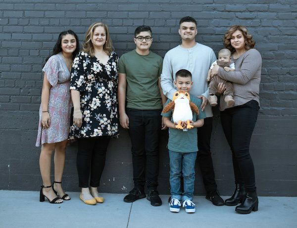People standing against a gray wall