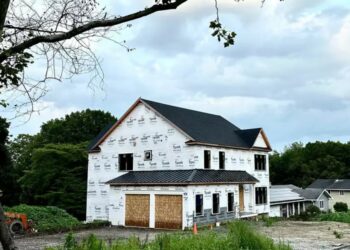 A luxurious $1.5 million house stands on a piece of land, with a legal dispute looming over its ownership, after the original landowner returns to find it built