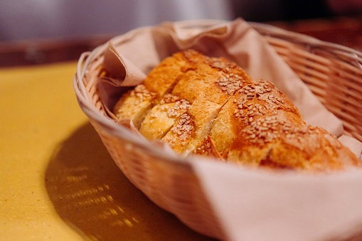 Close up shot of bread slices in wicker basket on napkin