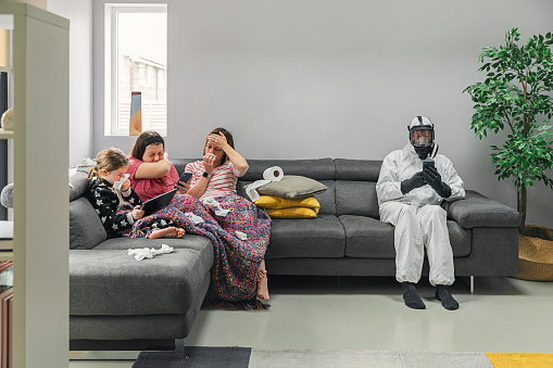 Family on sofa. Three has the flu. The dad isn't taking any risks!