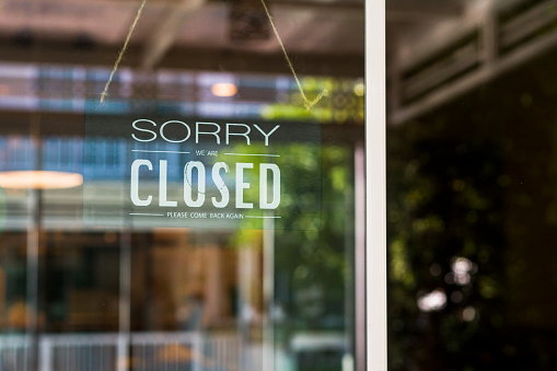 Store closed sign hanging on the window