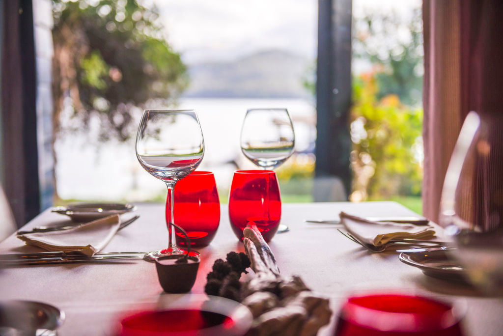 Table set up for dinner at a fine dining restaurant with wine glasses and beautiful views, Villa la Angostura, Neuquen, Patagonia, Argentina, South America