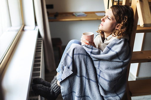 Young adult woman with flu drinking tea