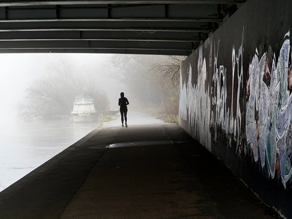 Under bridge over the Thames at Kennington, winter fog and jogger