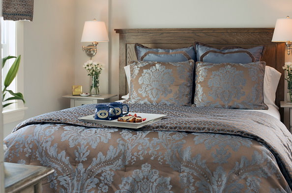 Vignette of made bed with coffee on tray
