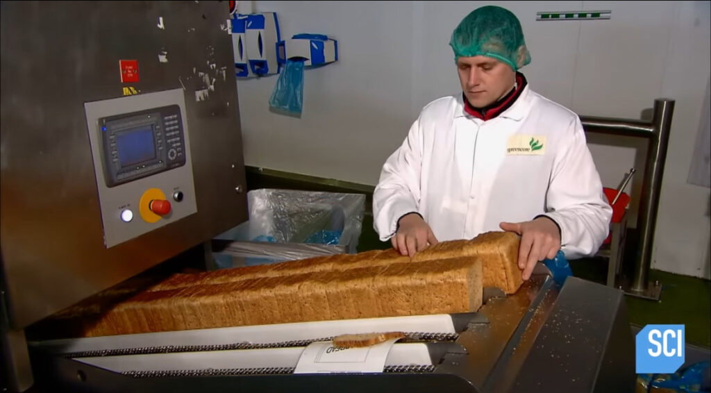 Factory worker checking over bread