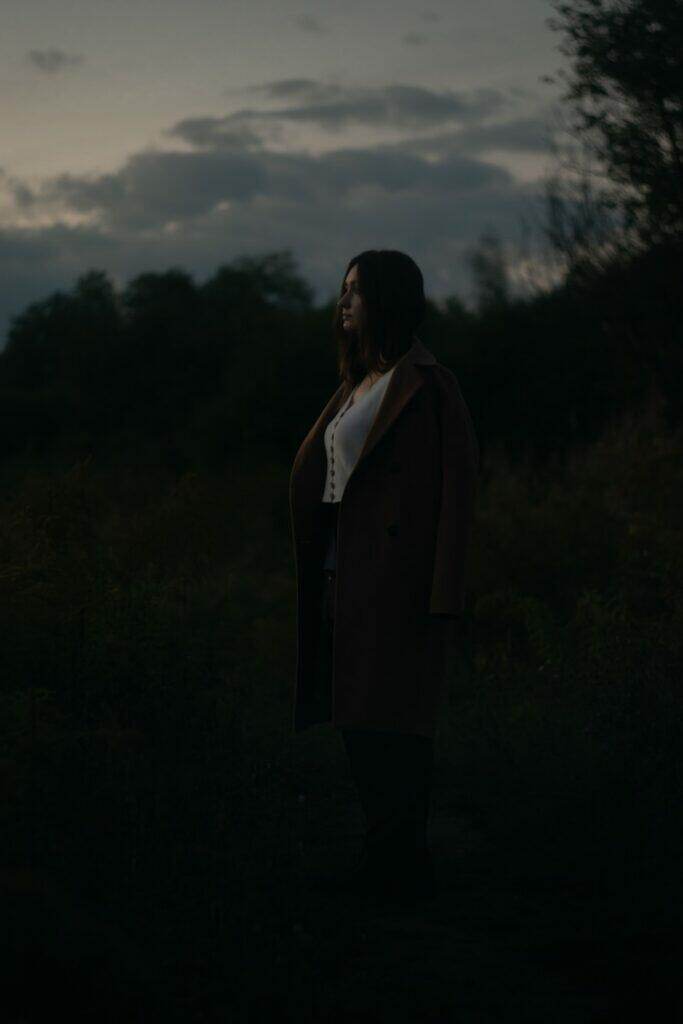 a woman standing in a field at night