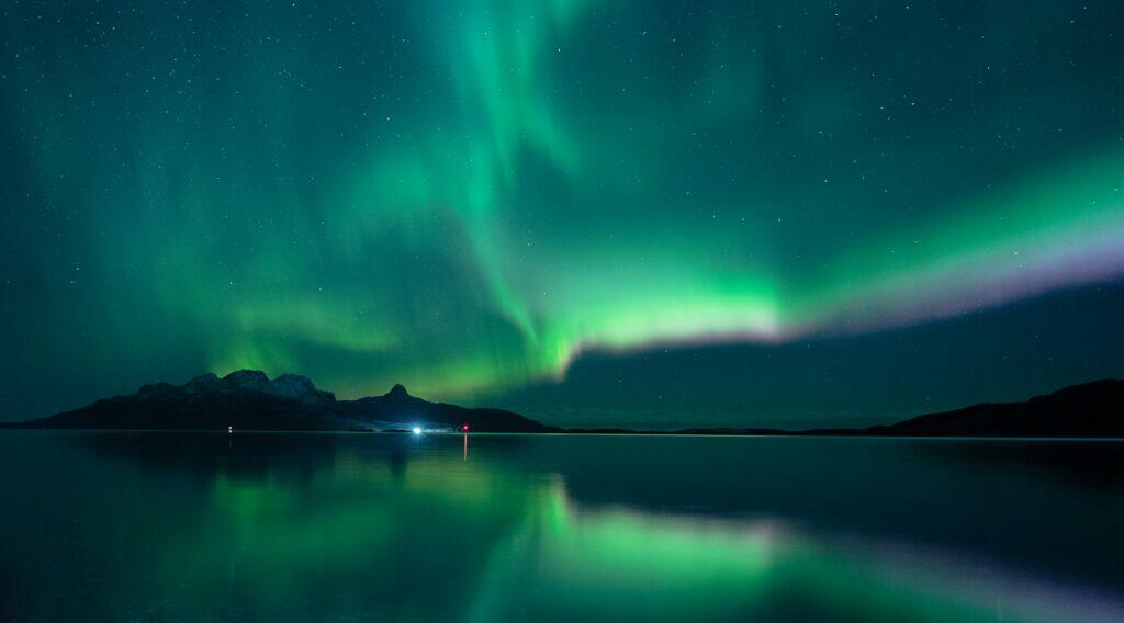 green aurora lights over lake