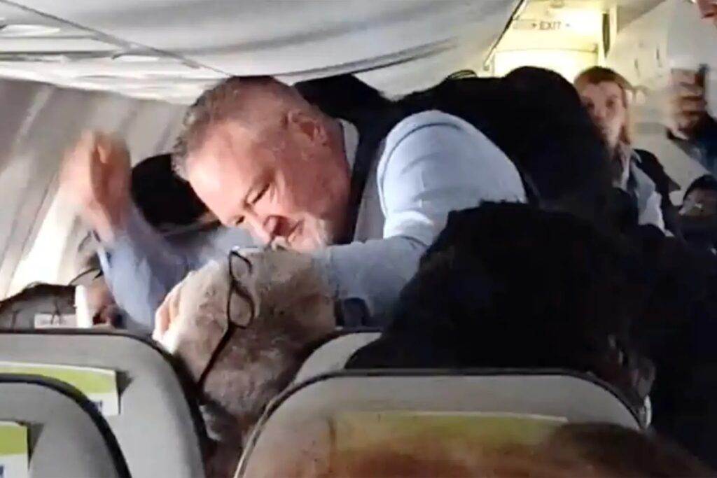 An Alaska Airlines flight attendant punches an unruly passenger in the throat and torso to force him to let go of a woman’s hair.