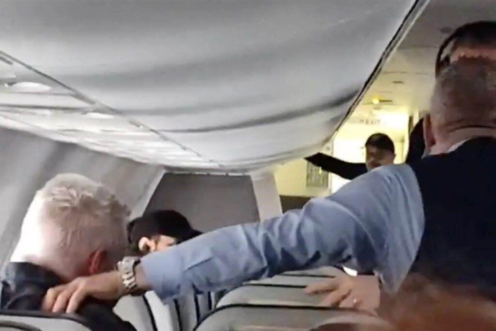 An Alaska Airlines flight attendant punches an unruly passenger in the throat and torso to force him to let go of a woman’s hair.