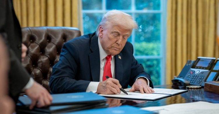 Donald Trump sitting at desk
