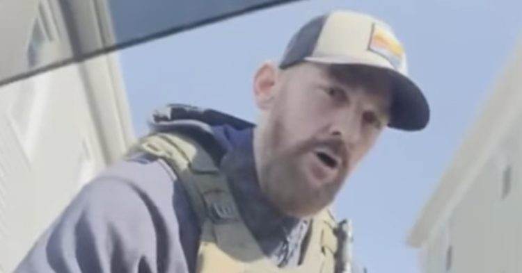 ICE agent detaining man in car