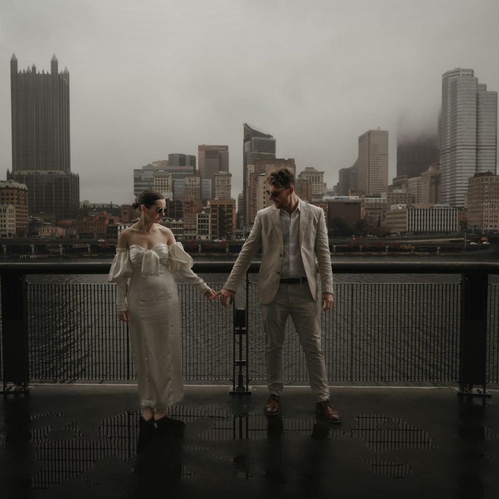 a man and a woman standing next to each other on a bridge