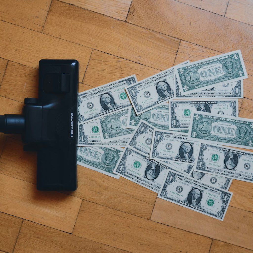 a pile of money sitting on top of a wooden floor