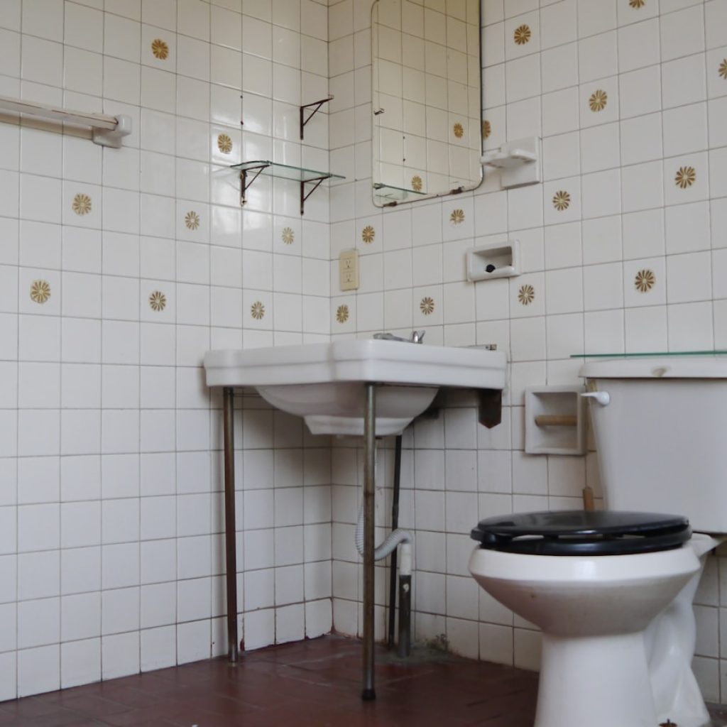 a white toilet sitting next to a white sink