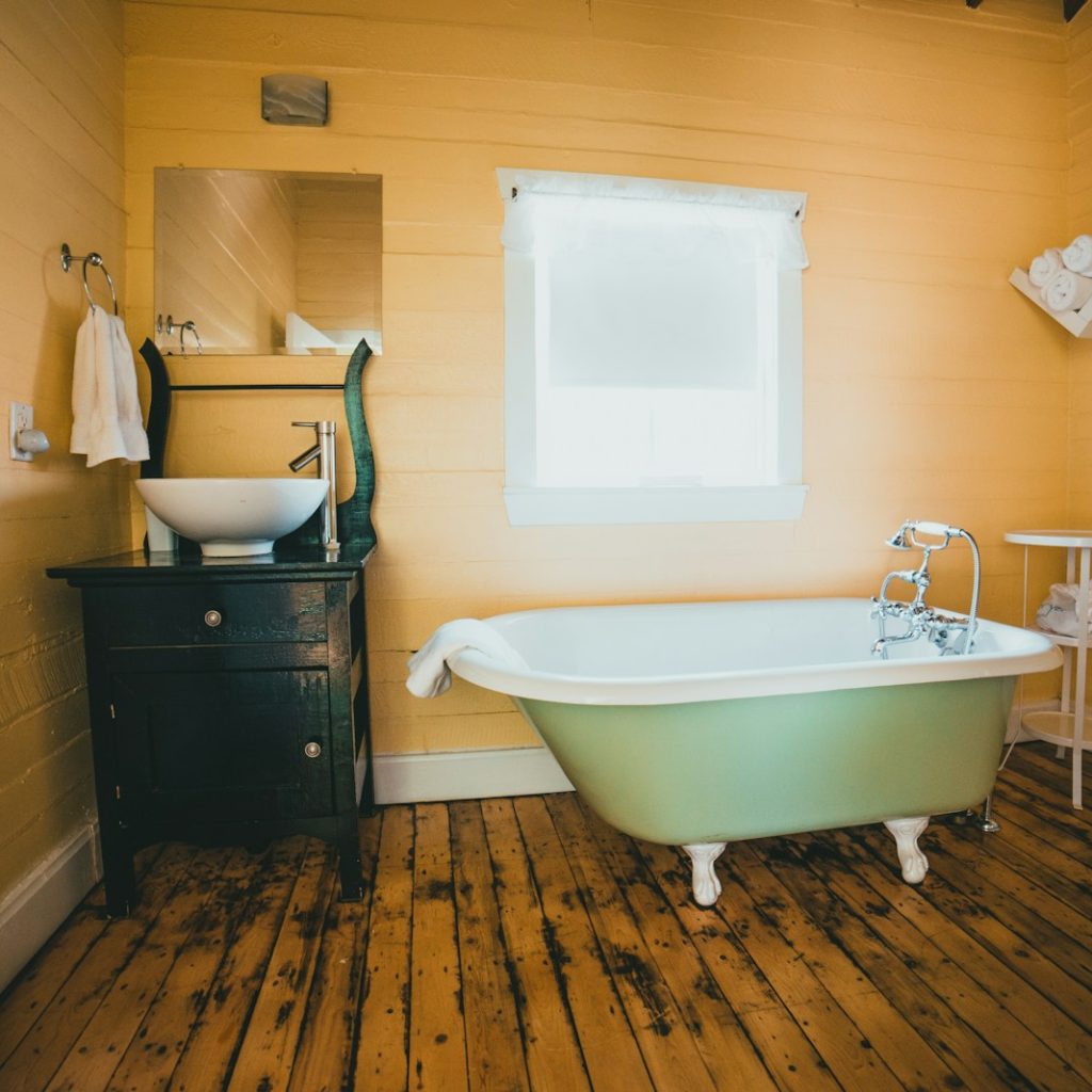 white bathtub on brown wooden floor