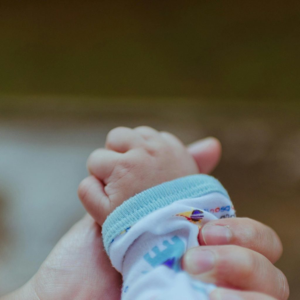 person holding baby's hand