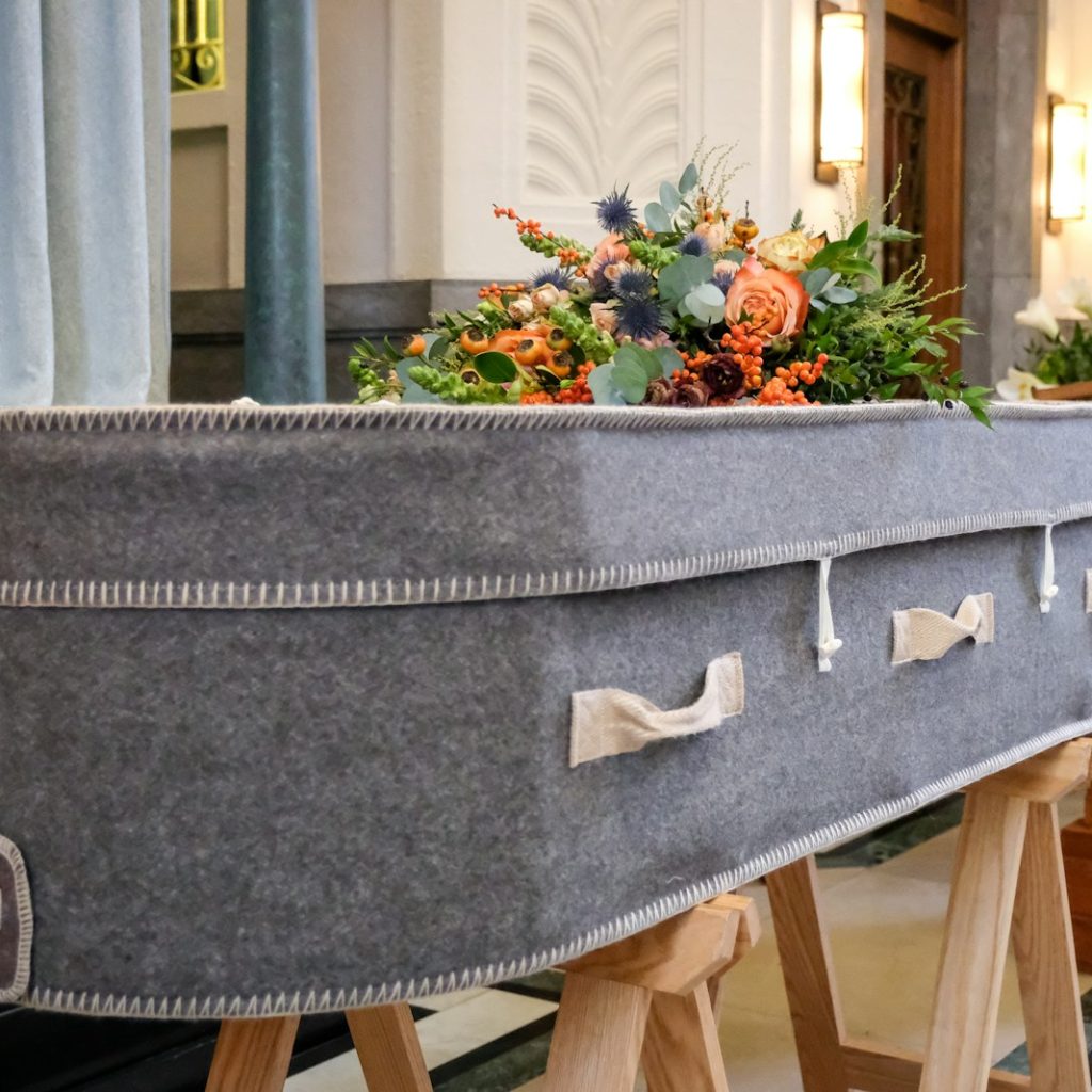 a large gray suitcase sitting on top of a wooden stand
