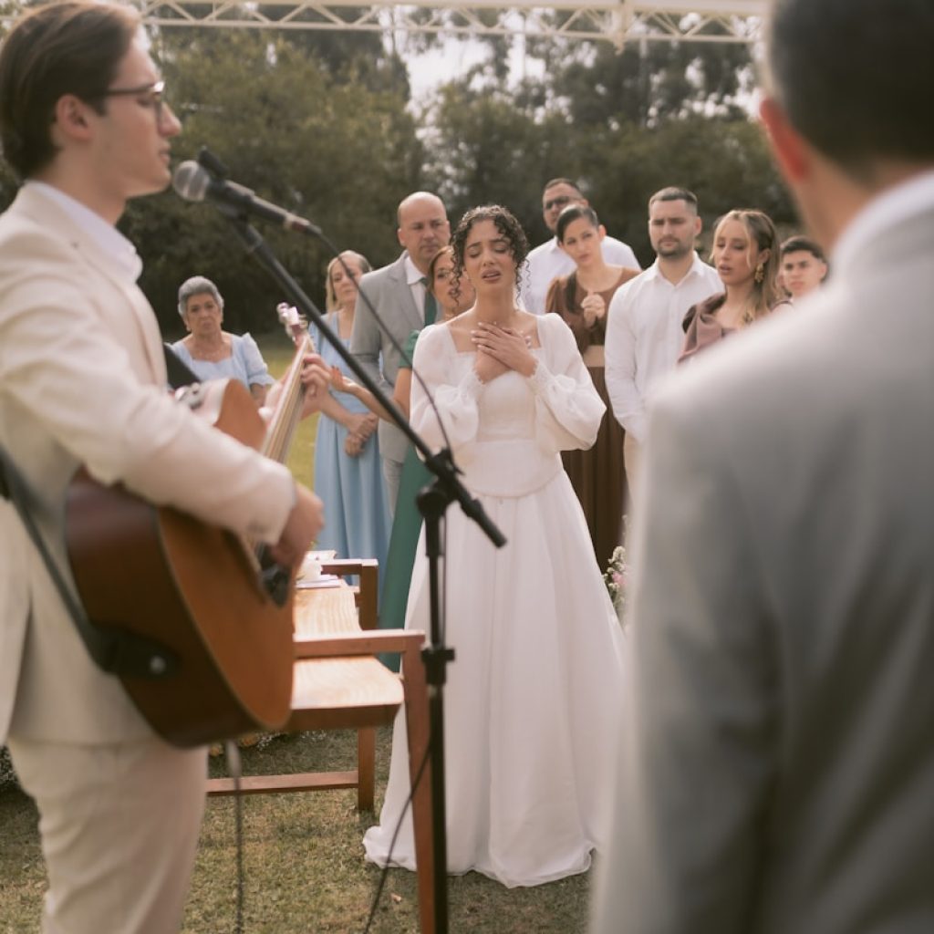 A bride listens to a song during an outdoor wedding.